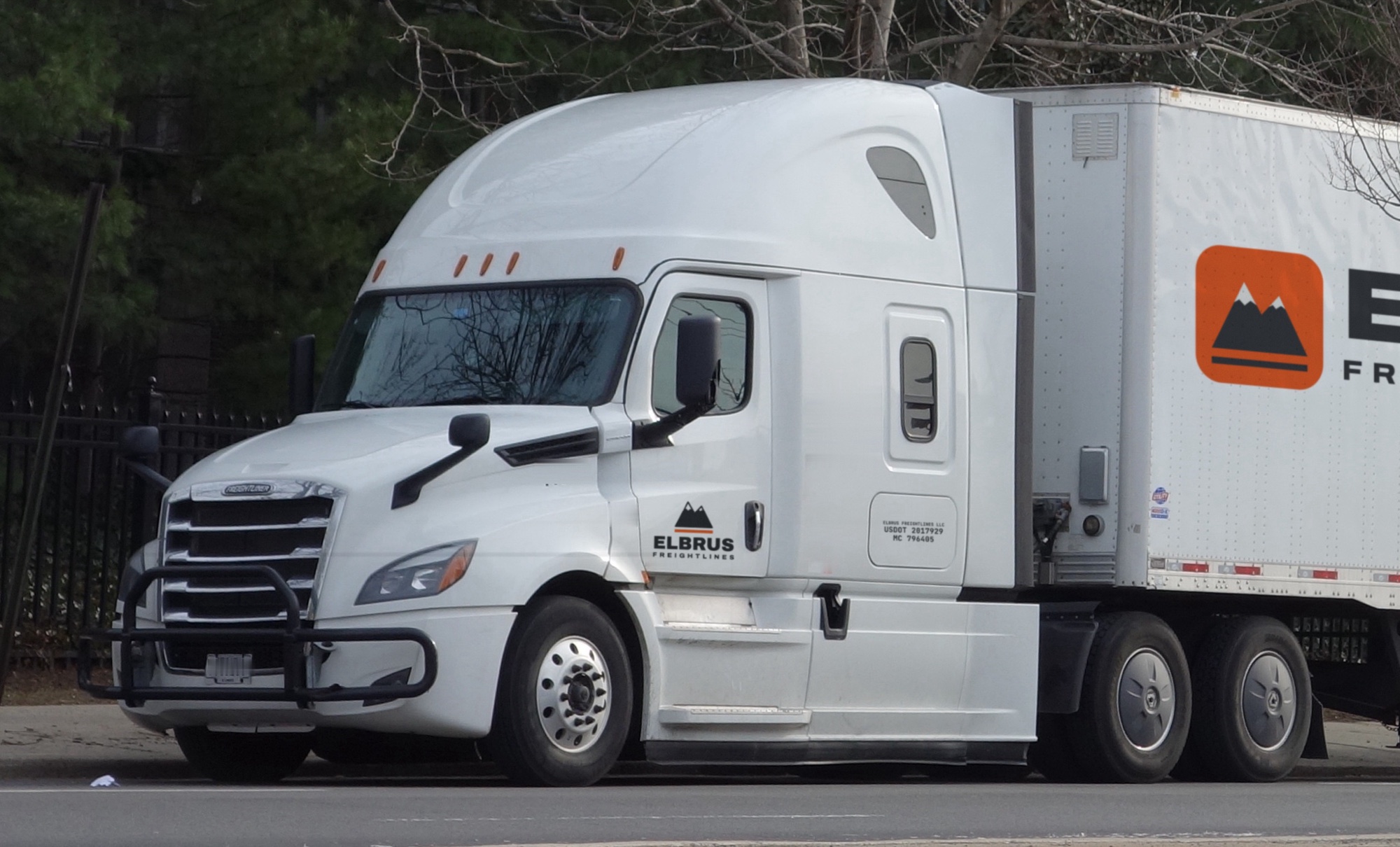 White Freightliner Cascadia with Elbrus Freightlines lettering on the cab door and trailer